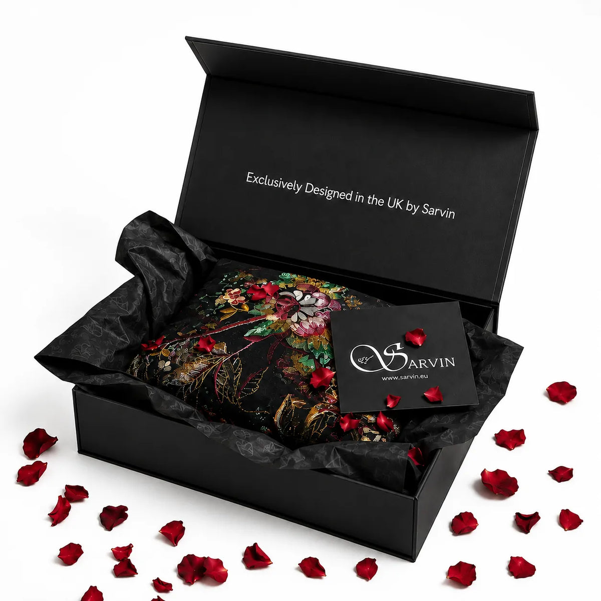 Presented within a black gift box featuring “Exclusively Designed in the UK by Sarvin” on the lid, you’ll find a beautiful floral-patterned garment, a Sarvin tag, black tissue paper, and red rose petals artfully scattered inside and around the box. Pair this thoughtful packaging with a Sarvin Gift Card from Sarvin for an unforgettable gifting experience.