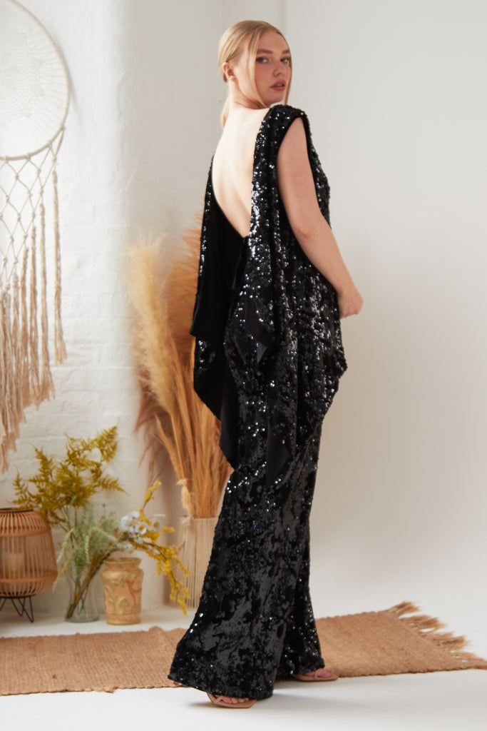 The back view of a woman wearing Sarvin's black Sequin Flared Trousers.