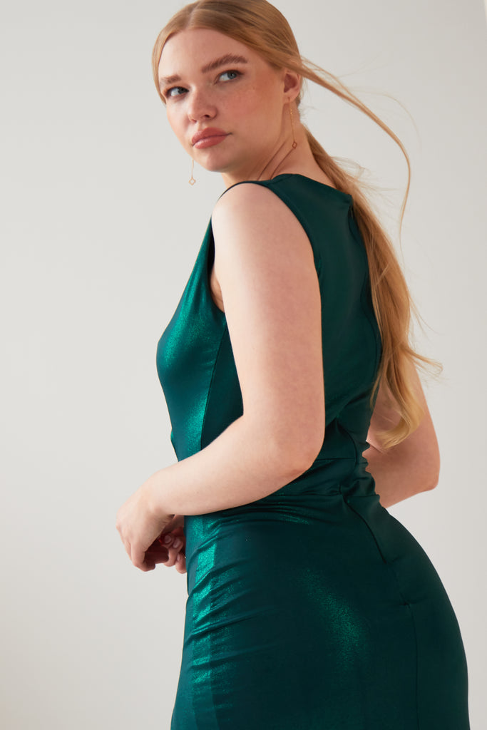 A woman wearing a Sarvin's Green Cut Out Side Dress.