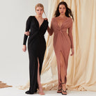 Two women wear Sarvin gowns: one in a black, long-sleeve floor-length dress with a twist knot front, deep V-neck, and thigh-high slit; the other in the Rose Gold Twist Knot Front Dress featuring the same elegant details.