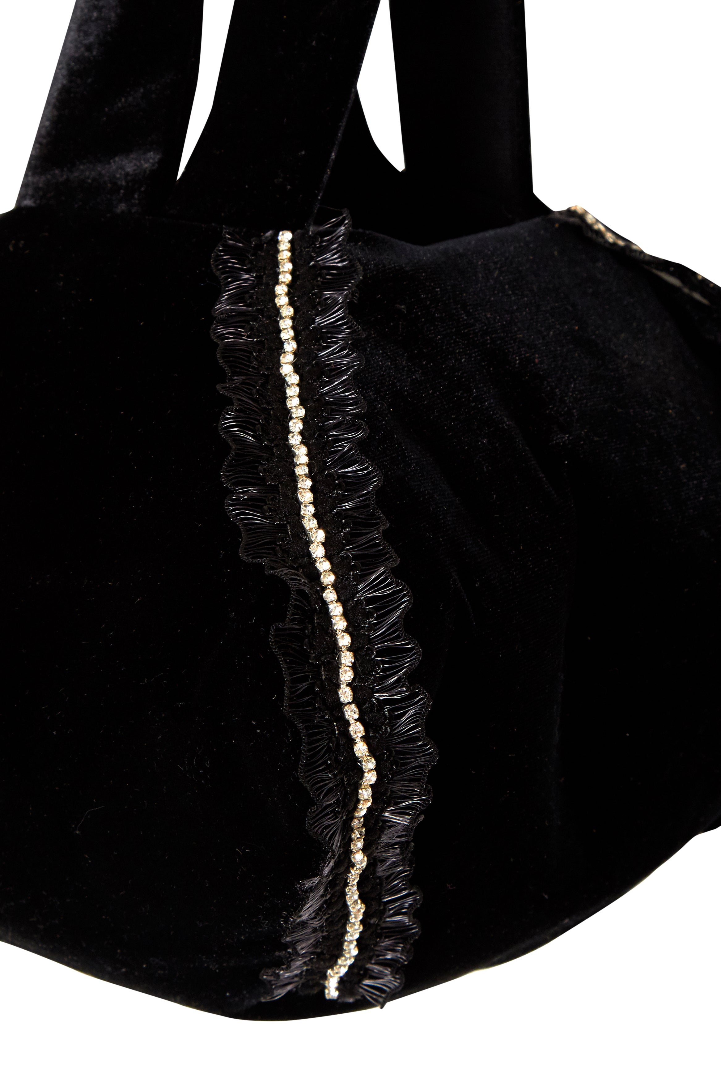 Close-up of Sarvin’s Diamond-Trimmed Lace Velvet Pouch Bag—an elegant black velvet evening accessory with lace trim, diamond-like beading along the edge, and soft black handles.