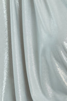A close-up of silver metallic fabric with a shiny, reflective surface and soft folds—ideal for creating the Sarvin Batwing Sleeve Midi Dress, perfect for a show-stopping party look.