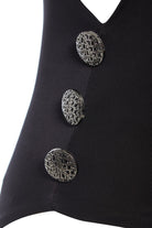Close-up of Sarvin's Dropped Armhole Bodysuit in silk-touch jersey, showcasing three large, round silver buttons with textured abstract patterns vertically aligned on the front.