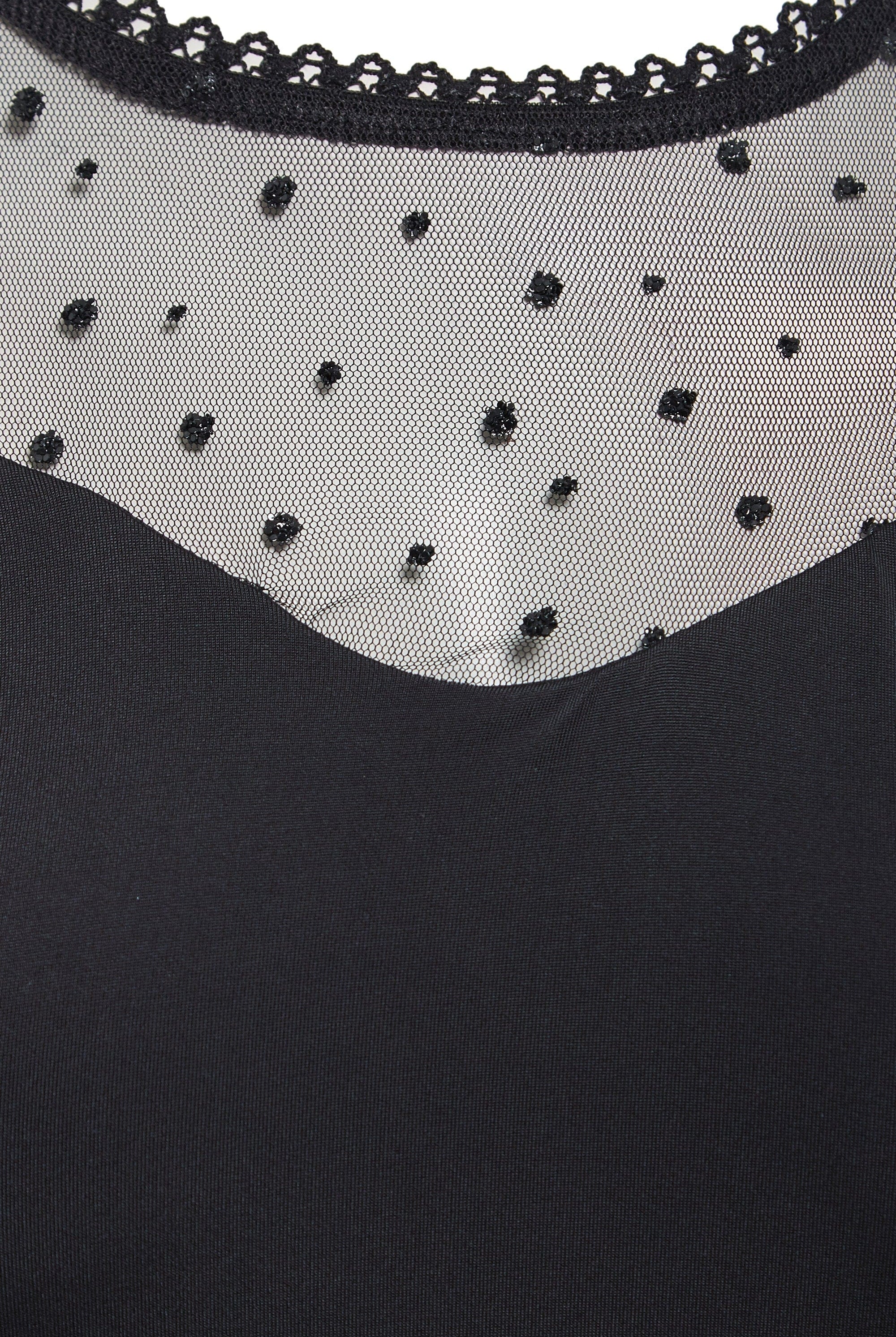 Close-up of the Sarvin Long-Sleeve Mesh Bodysuit, showcasing sheer black mesh with small polka dots and a delicate lace-trimmed neckline.
