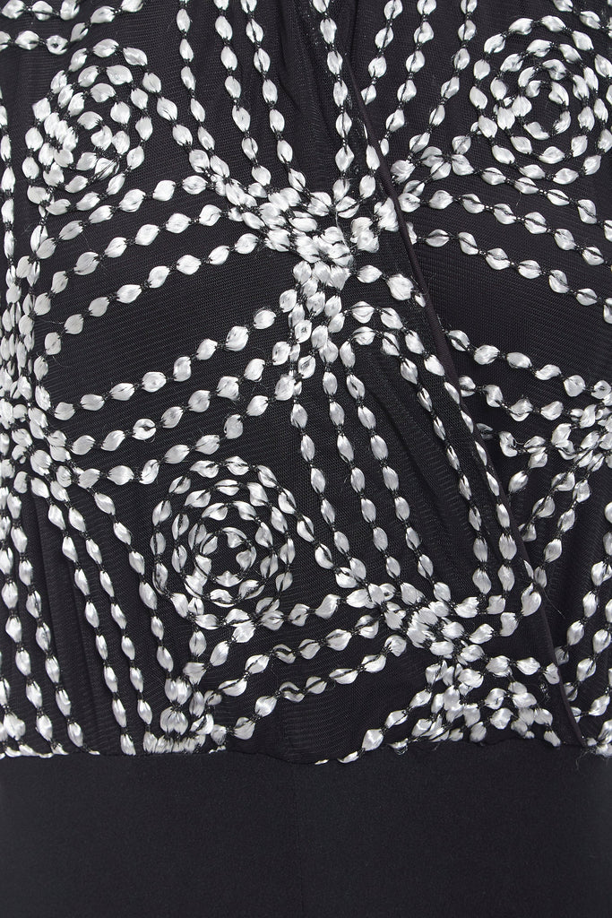 a Sarvin Black Backless Jumpsuit with a white and silver pattern.