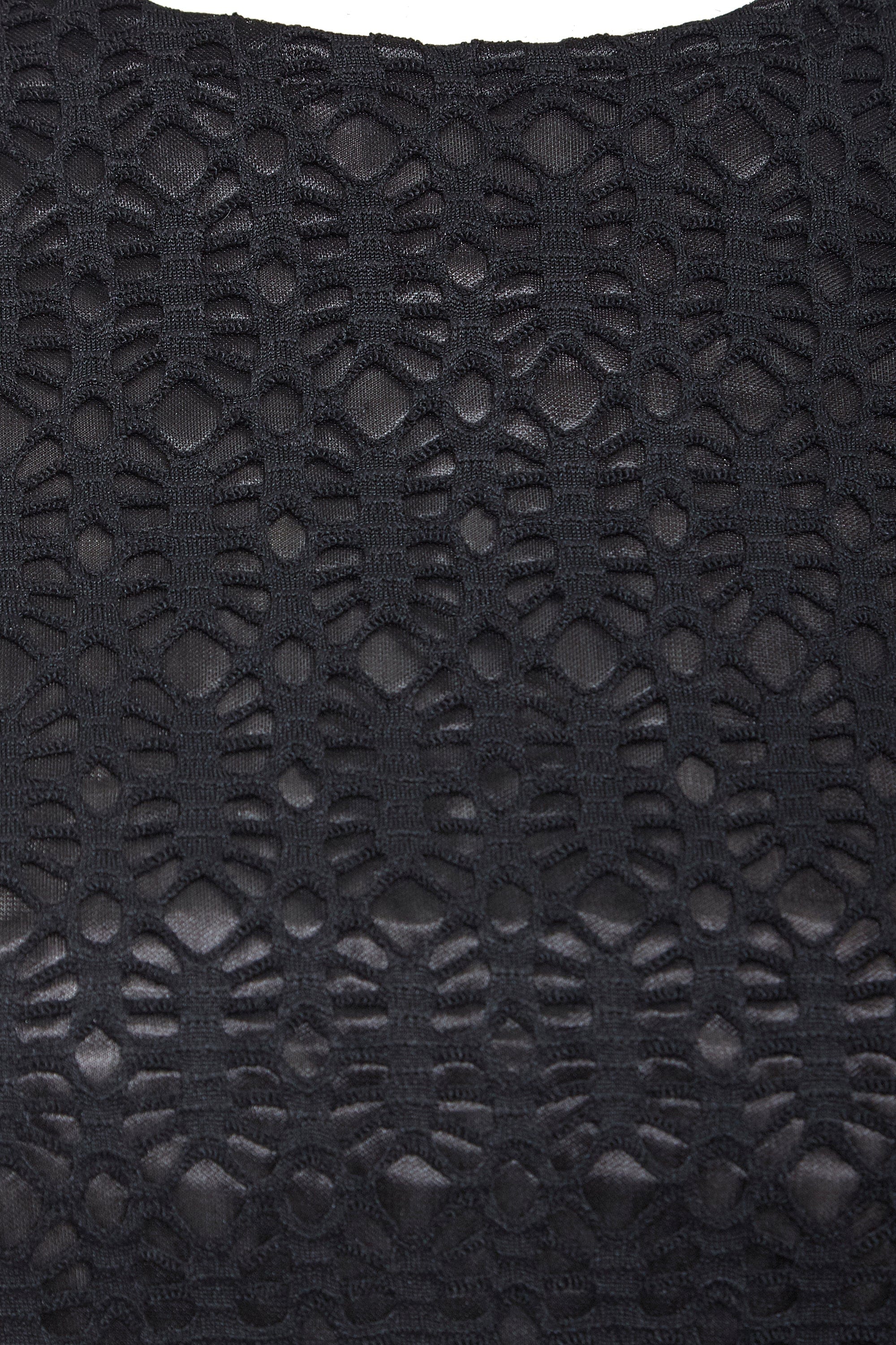 Close-up of the Black Twisted Backless Dress by Sarvin, highlighting its geometric black lace with open and solid sections for a textured, intricate look. The semi-sheer lace adds depth, making it ideal for a standout style.