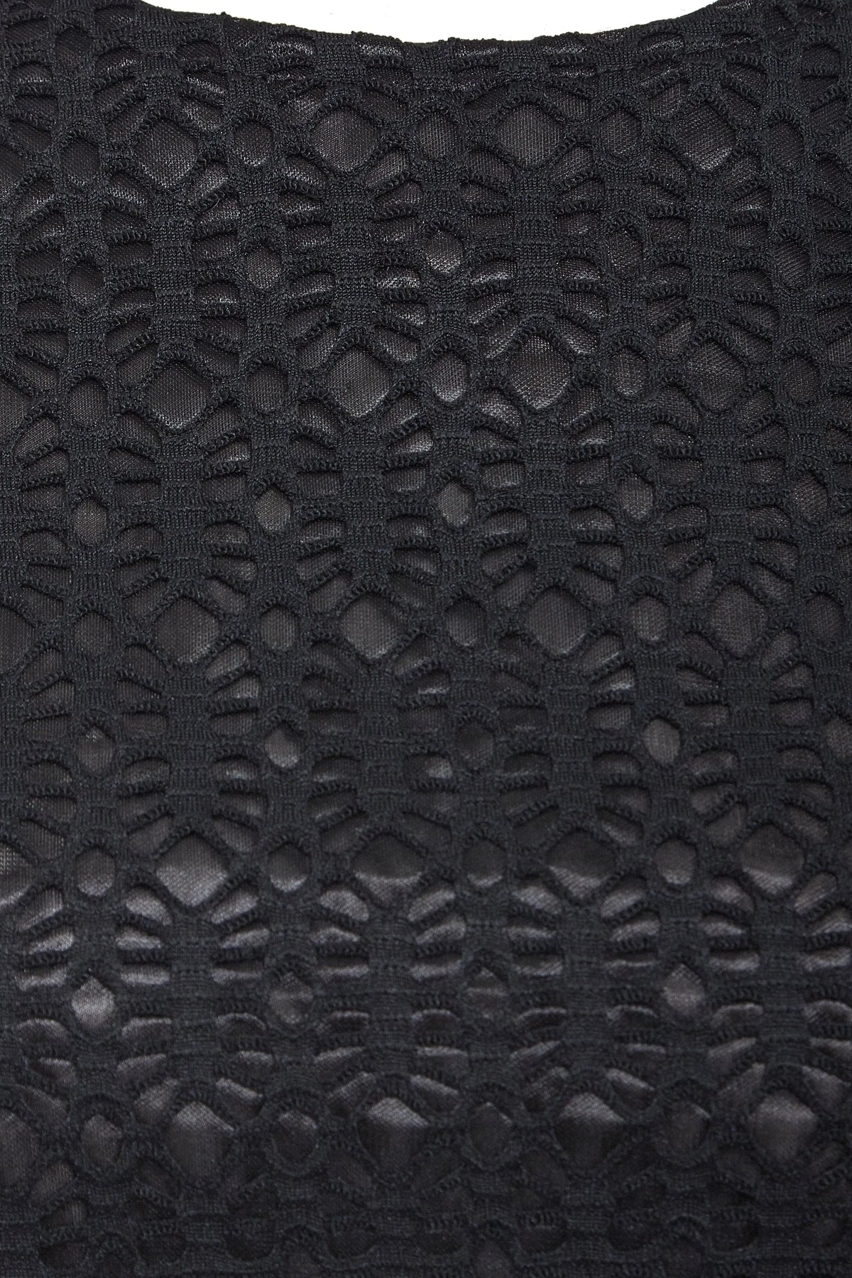 Close-up of the Black Twisted Backless Dress by Sarvin, highlighting its geometric black lace with open and solid sections for a textured, intricate look. The semi-sheer lace adds depth, making it ideal for a standout style.