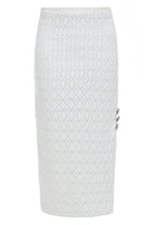 The Sarvin White Bodycon Lace Skirt is a high-waisted, knee-length skirt handmade in the UK, featuring a textured floral lace pattern and three decorative buttons on the right side.