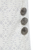 Close-up of Sarvin's White Bodycon Lace Skirt, handmade in the UK with a high waist, featuring three textured silver buttons on the right over floral lace and a shiny white lining.