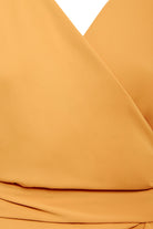 Close-up of the Sarvin Mustard Wrap Maxi Dress, showcasing a V-neckline and overlapping fabric with elegant waist folds.