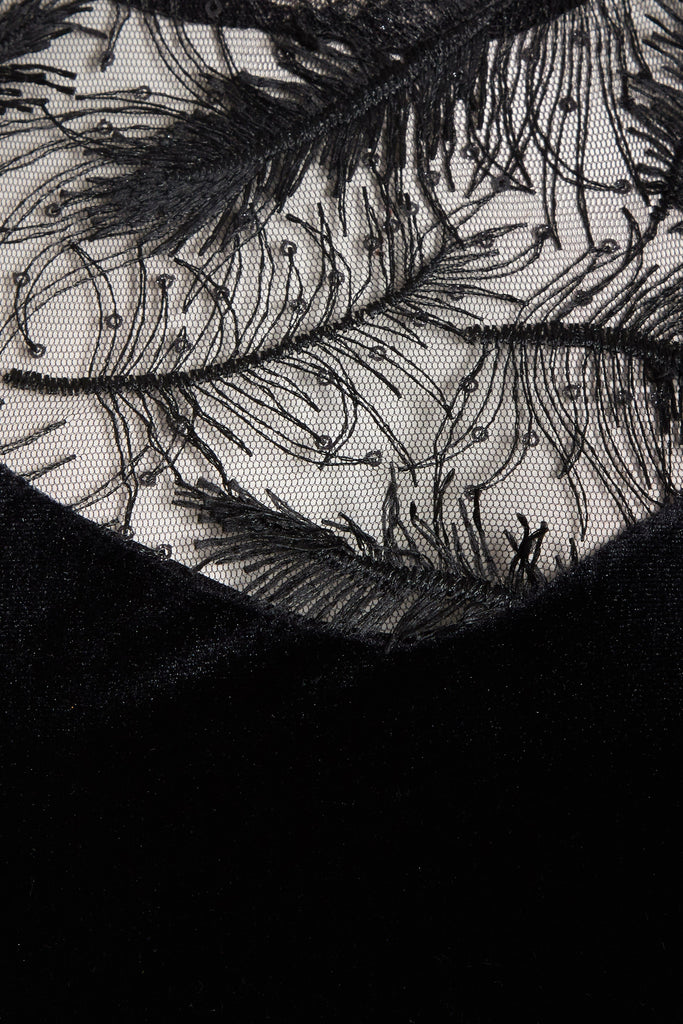 a close up of a Sarvin black Velvet Bodycon Dress with feathers on it.
