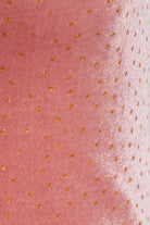 Close-up of the Sarvin Pink Velvet Polka Dot Dress, featuring a shiny texture with evenly spaced small gold dots—ideal for elegant evening occasions.
