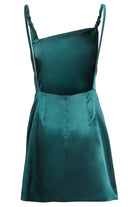 The Sarvin Emerald Green Mini Dress is a sleeveless silk satin mini dress featuring an asymmetrical neckline, braided shoulder straps, and a back zip closure.