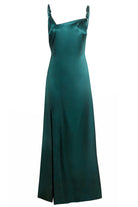 The Sarvin Emerald Green Maxi Dress features a sleeveless satin design with a straight neckline, high side slit, and decorative knots on the straps—an elegant black-tie look shown against a plain white background.