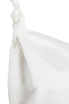 Close-up of a white satin fabric bag with a knotted strap, its smooth, shiny texture echoing the elegance of Sarvin's A-Line Mini Slip Dress.