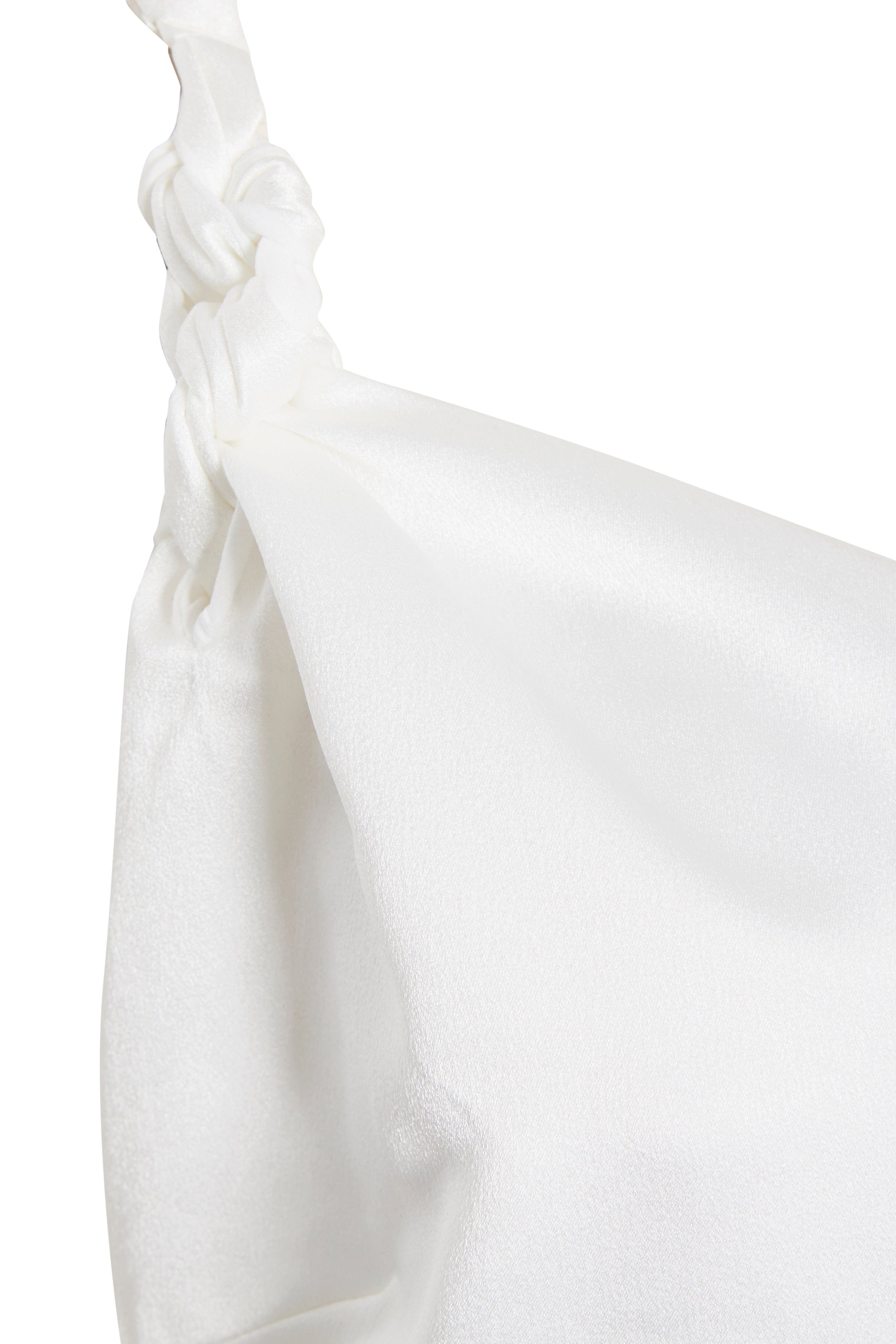 Close-up of a white satin fabric bag with a knotted strap, its smooth, shiny texture echoing the elegance of Sarvin's A-Line Mini Slip Dress.