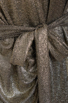 Close-up of Sarvin's Long Sleeve Sequin Wrap Dress, featuring a shiny, mesh-like gold fabric with a central knot detail—perfect for glamorous evening wear.