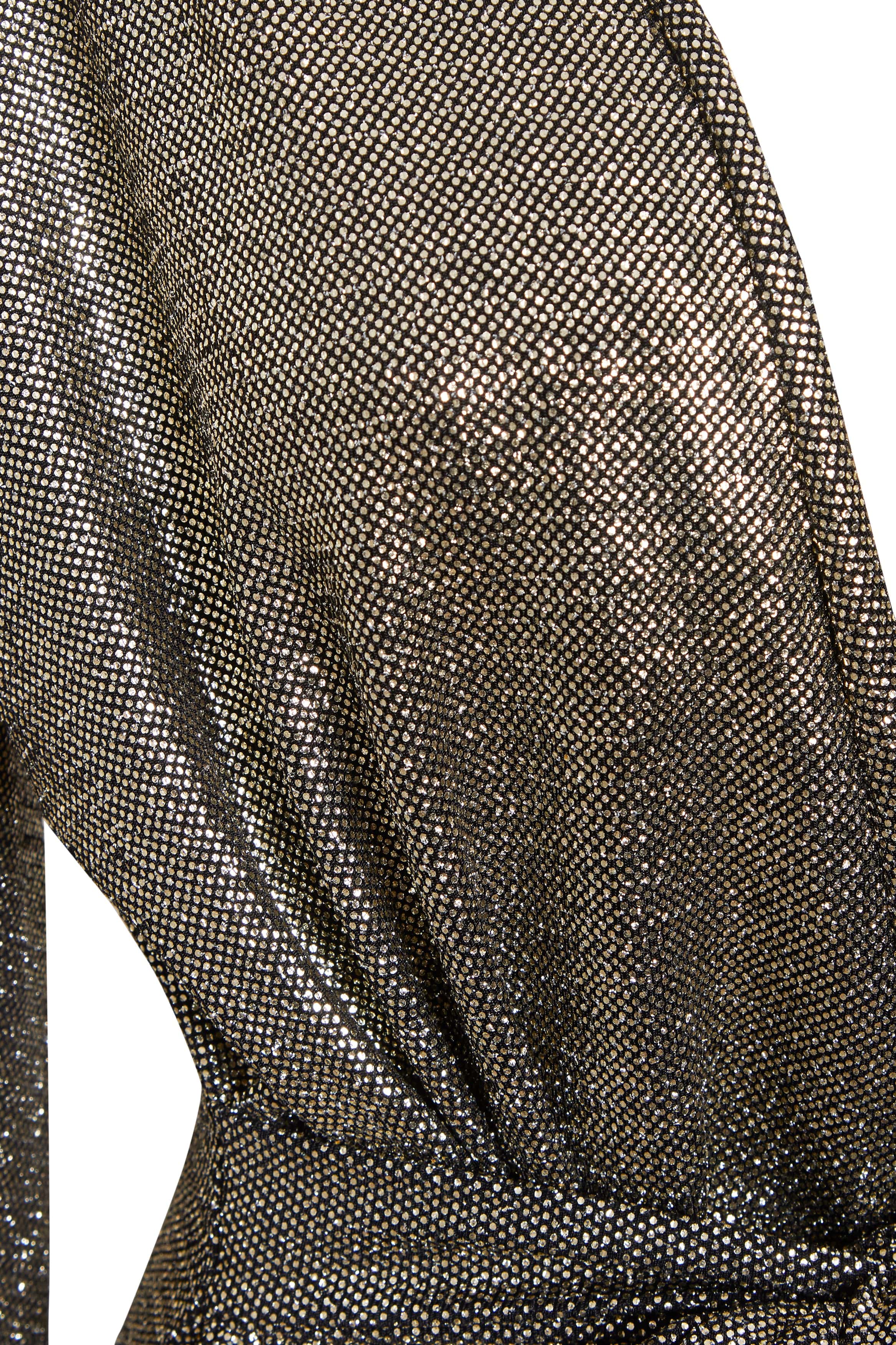 Close-up of Sarvin's Long Sleeve Sequin Wrap Dress, featuring metallic, shimmering fabric with a fine mesh pattern draped at the waist. The material reflects light beautifully, creating a textured effect perfect for evening wear.