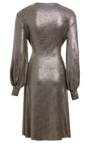 The Sarvin Long Sleeve Sequin Wrap Dress features a metallic silver finish, fitted waist, flared skirt, and loose cuffed sleeves. Its shiny, textured fabric makes it ideal for special occasions. Shown here from the back view.