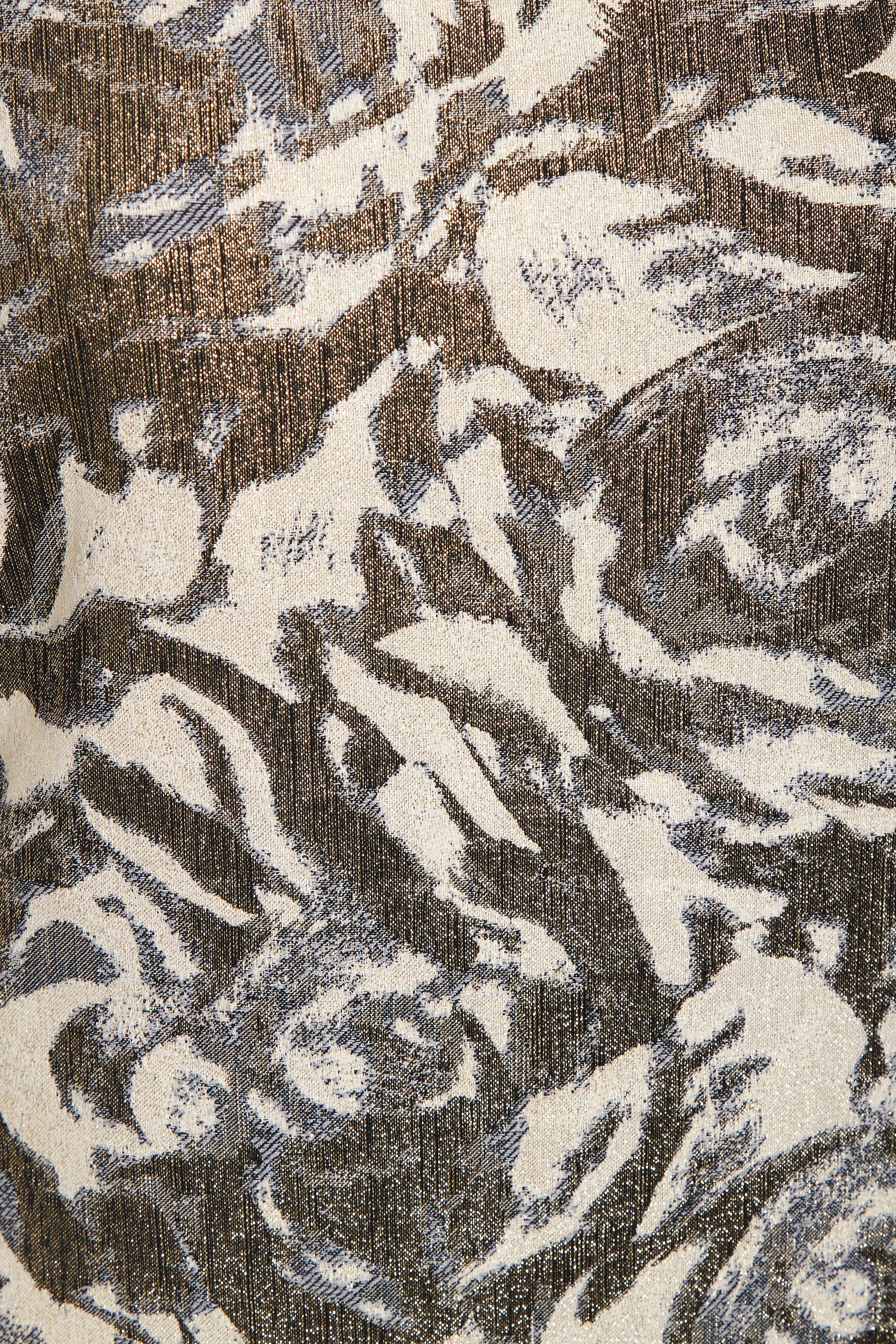 A close-up of Sarvin's Puff Shoulder Mini Dress shows its textured golden floral jacquard fabric with an abstract cream, brown, and gray pattern, slight sheen, and visible woven threads.