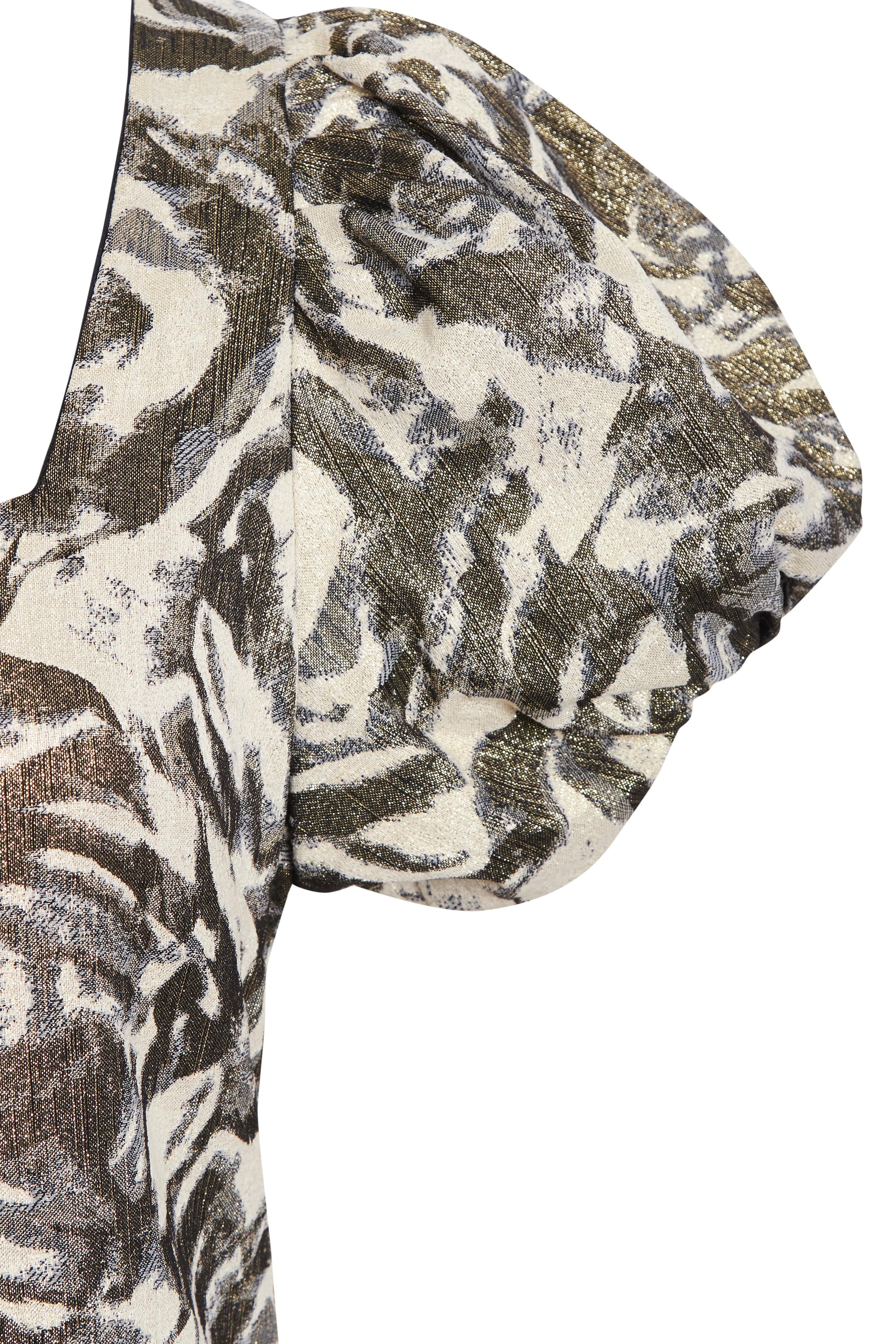 Close-up of the Sarvin Puff Shoulder Mini Dress, featuring voluminous short sleeves with gathered detailing in textured fabric. An abstract black, gold, and cream pattern evokes golden floral jacquard.