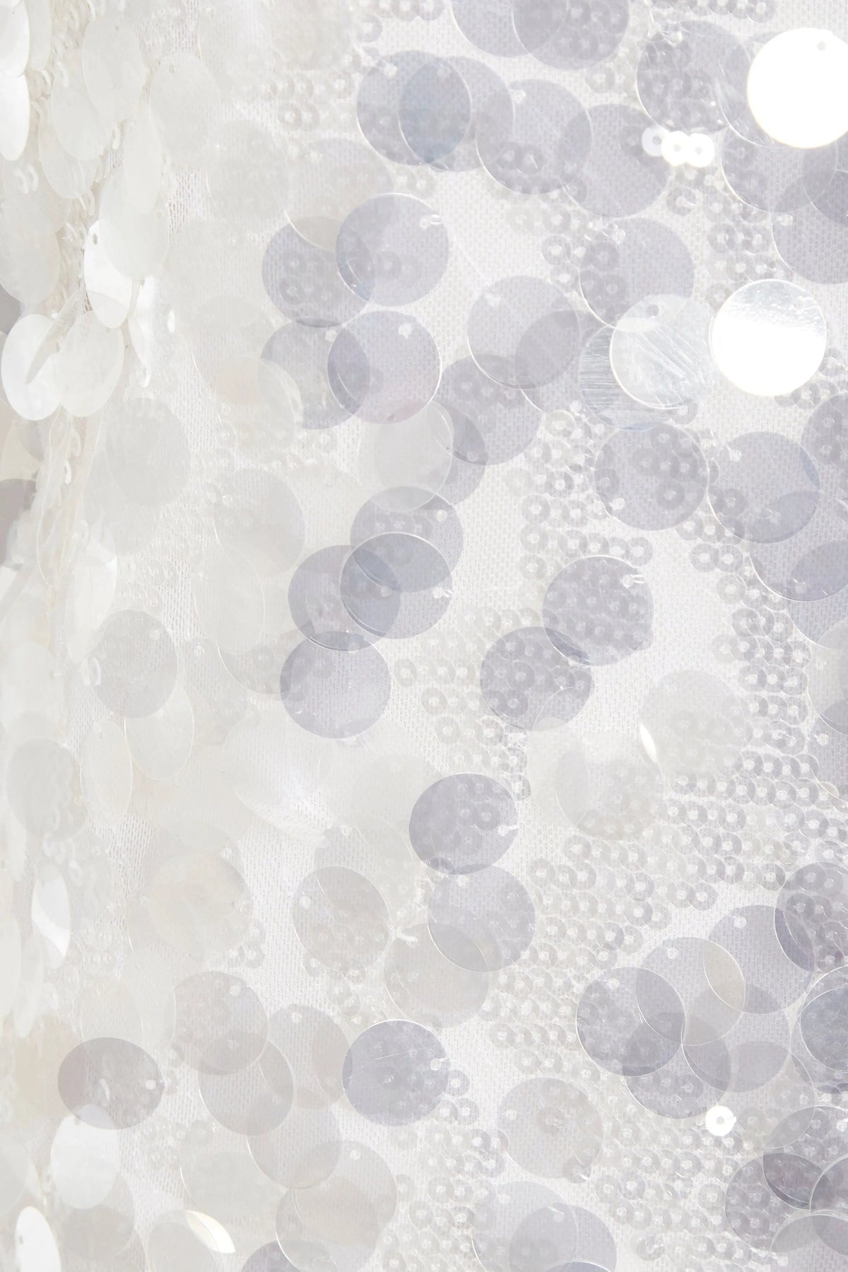 Close-up of shiny white sequins sewn onto sheer fabric, creating a textured, reflective look on the Sarvin White Sequin Backless Mini Dress—perfect for making a dazzling entrance.