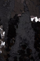 Close-up of dense, overlapping black sequins creating a shiny, reflective texture—ideal for the Sarvin Sparkly Black Mini Dress, perfect for making a statement with its eye-catching sparkle.