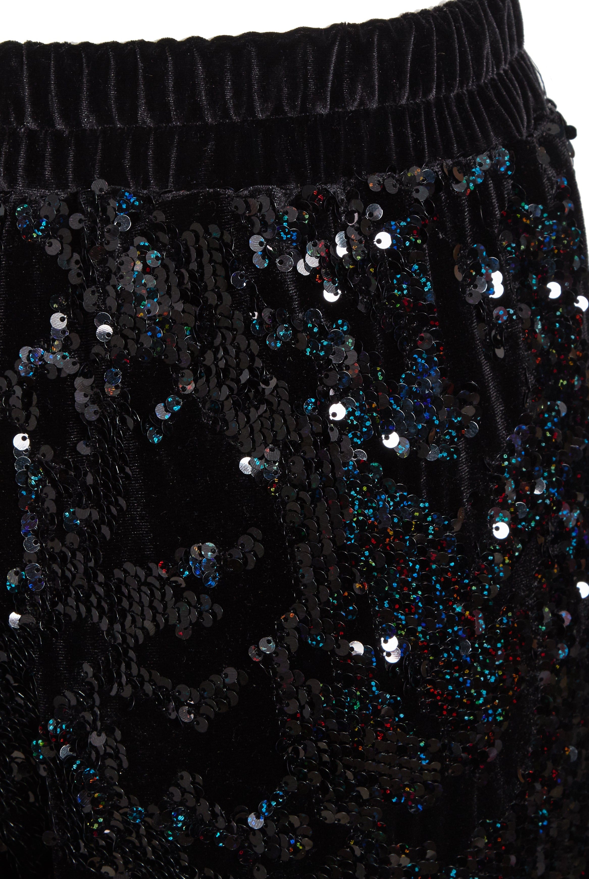 Close-up of Sarvin Sequin Velvet Flared Trousers: black velvet with an elastic waistband, embellished with shiny black and multicolored sequins in an abstract pattern—ideal for standout party wear. Handmade in the UK.