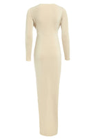 The Sarvin Low Cut Midi Dress is shown from the back in beige. This long bodycon dress has long sleeves, a simple design, and subtle seam detail below the shoulder blades, with no visible embellishments.