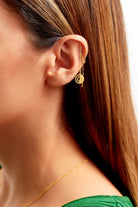 A close-up shows a person with straight brown hair in a green top wearing Sarvin's Circle Shape 18K Gold Drop Earrings and a thin gold necklace.
