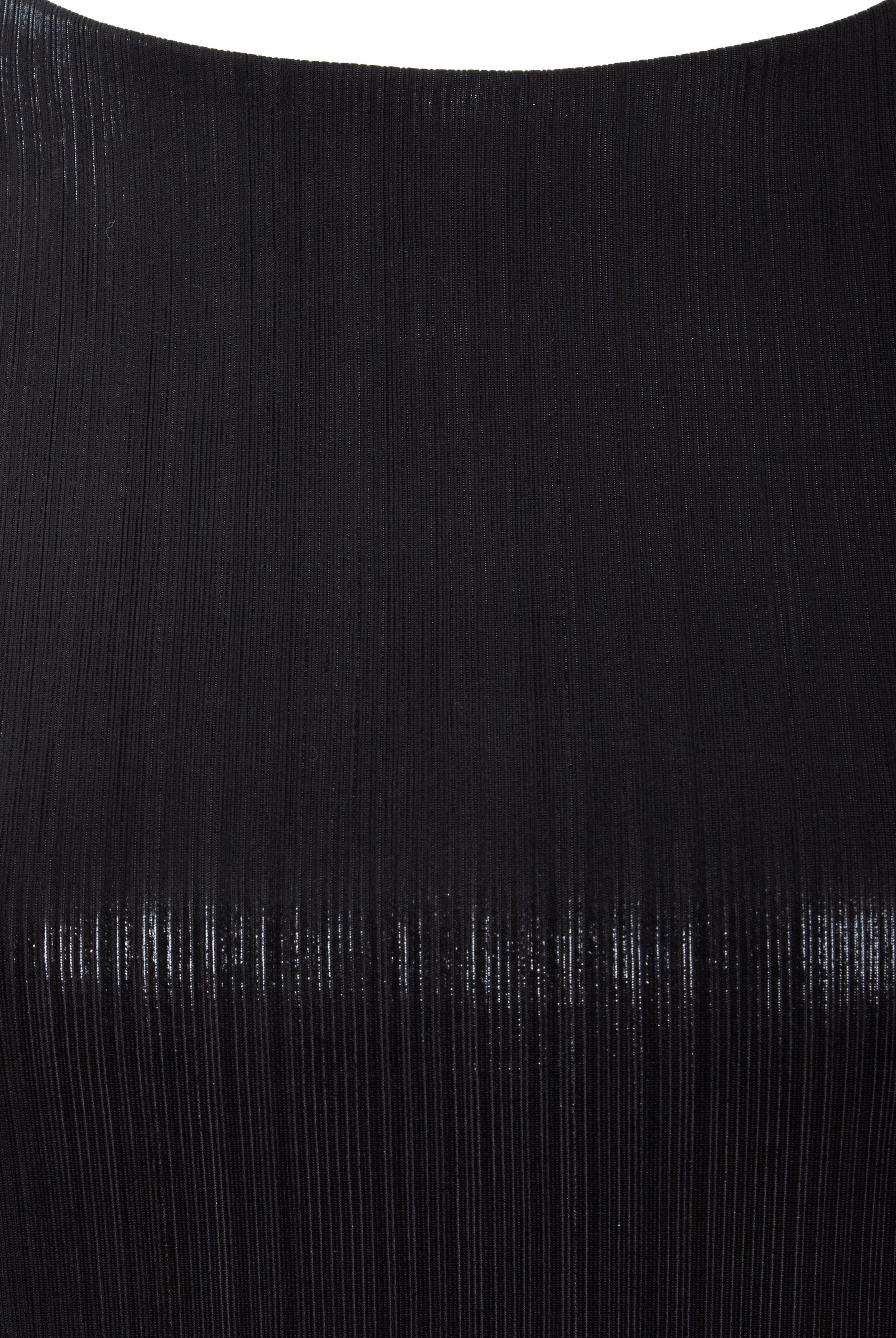 Close-up of the Sarvin Black Cut-Out Maxi Dress reveals finely ribbed fabric with a subtle sheen, vertical textured lines, and a smooth, curved upper edge—perfect for an elegant evening look.