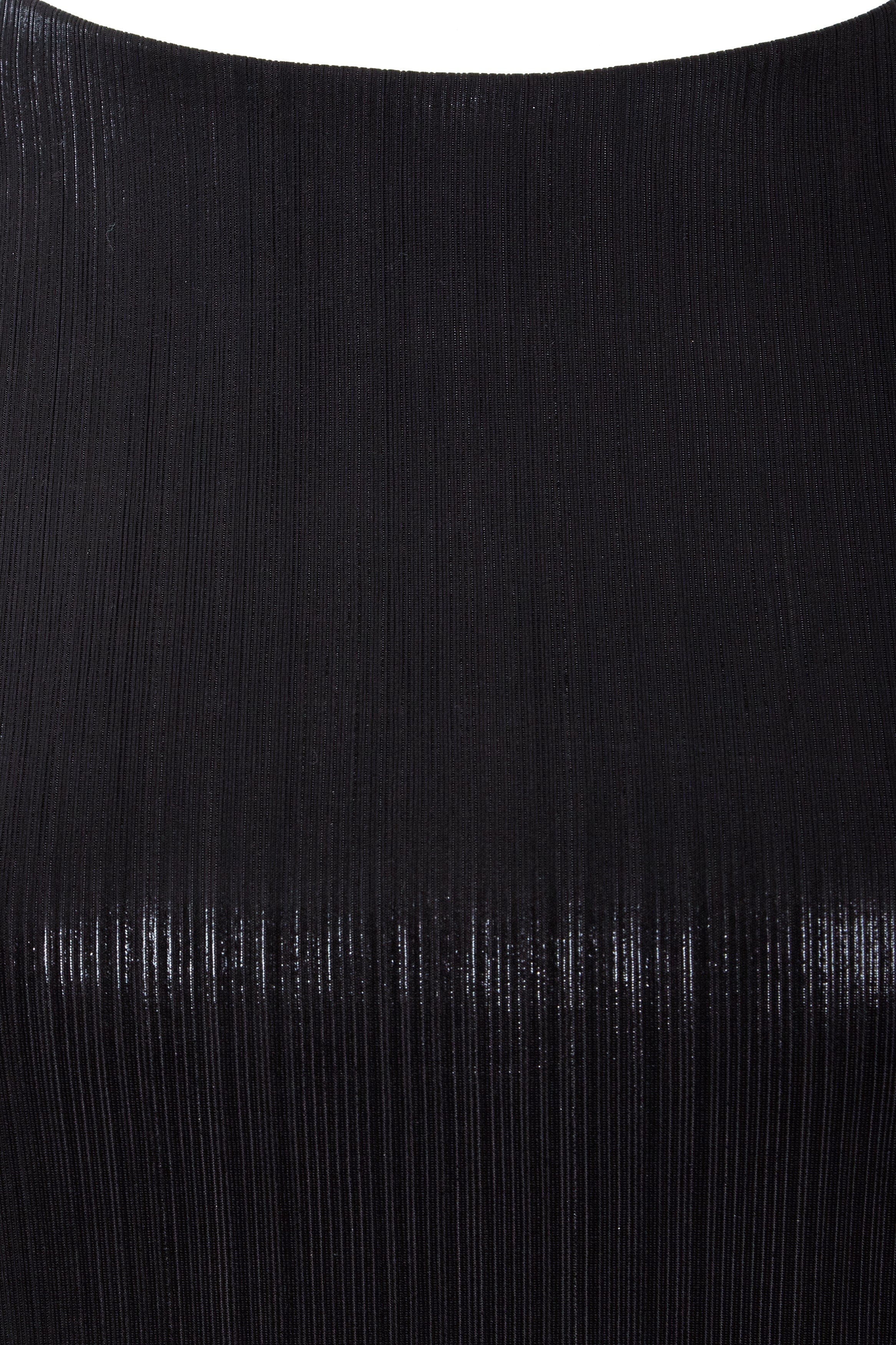 Close-up of the Sarvin Black Cut-Out Maxi Dress reveals finely ribbed fabric with a subtle sheen, vertical textured lines, and a smooth, curved upper edge—perfect for an elegant evening look.