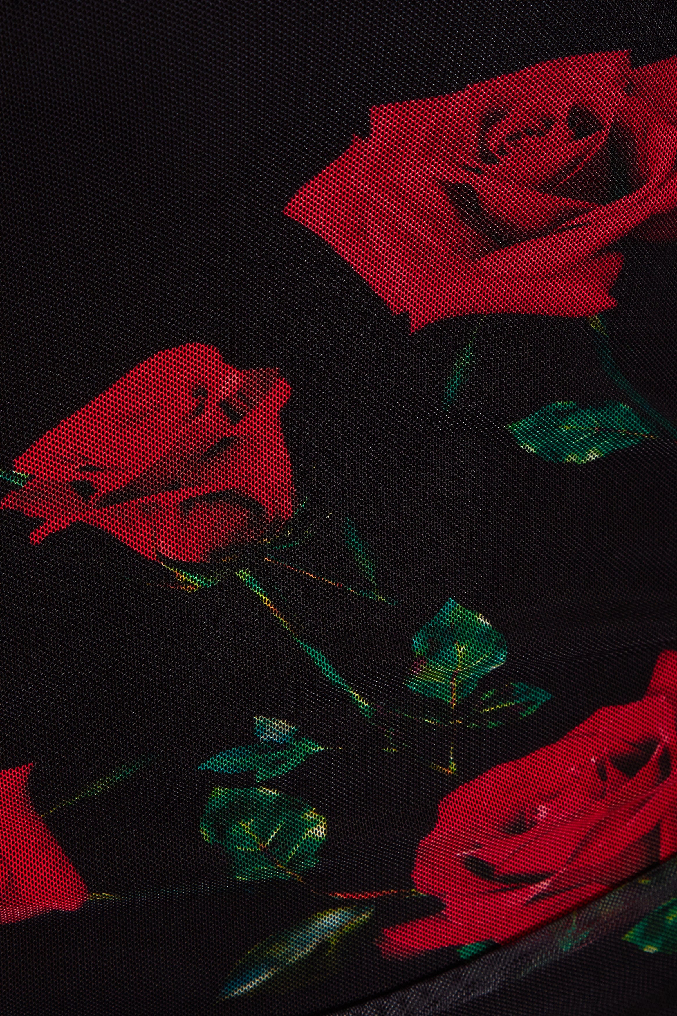 Close-up of black fabric with large red roses and green leaves, showing detailed texture—ideal for a UK-made Ruched Bodycon Mini Dress by Sarvin.