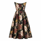 The Sarvin Golshifteh Floral Corset Midi Dress features a sleeveless, strapless fitted bodice and flared skirt, with red, gold, and cream floral prints on black. Displayed against a white backdrop.