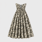 The Tala Corset Midi Dress by Sarvin is a strapless, ankle-length dress with a black and white floral pattern, featuring a fitted bodice with black lace-up front detail and a full gathered skirt for an elegant hourglass silhouette.