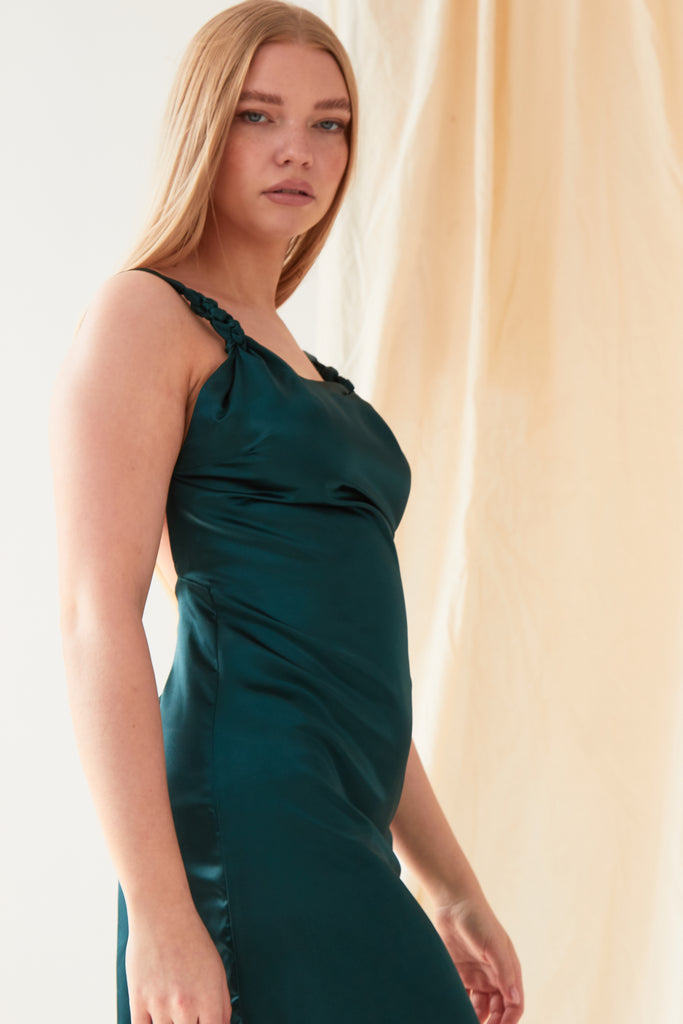 The model is wearing a Sarvin Green Backless Mini Dress.
