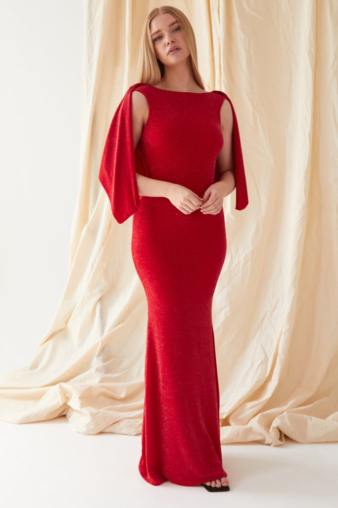 The model is wearing a Sarvin Red Cowl Back Gown with sleeved sleeves.