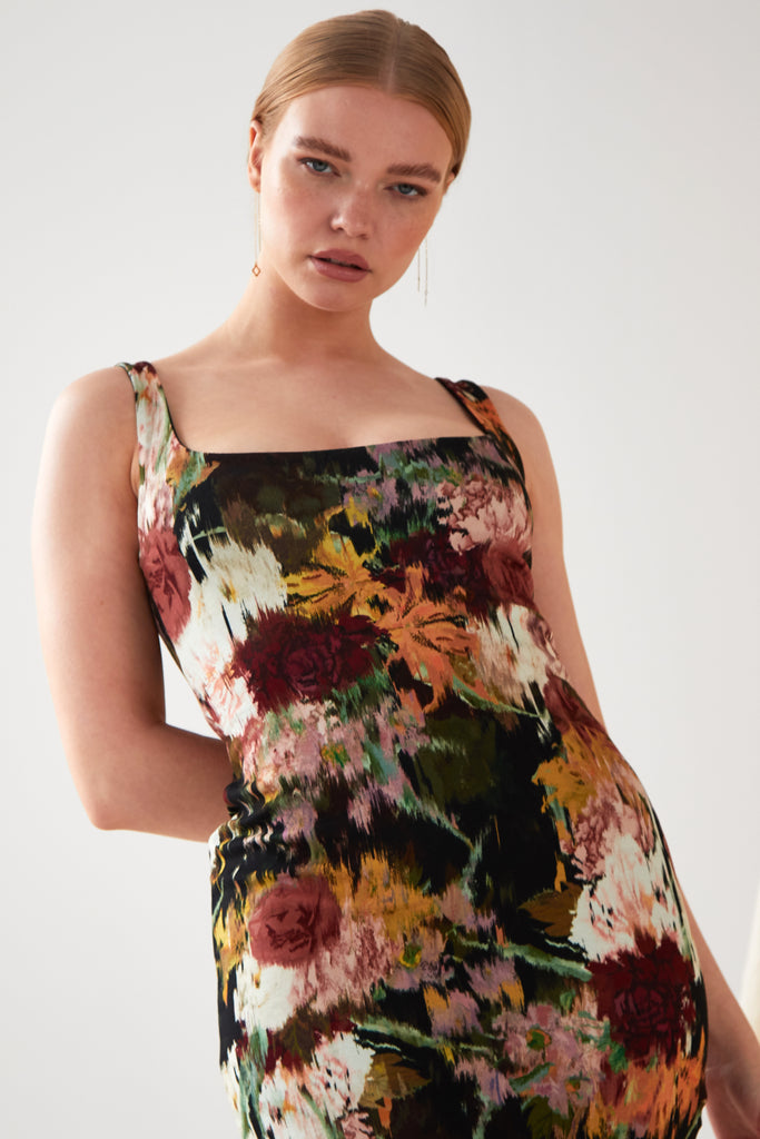The model is wearing a Sarvin Sleeveless Floral Bodycon Dress.