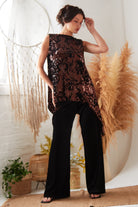 the model is wearing a sequin top and Sarvin black Wide Leg Velvet Trousers.