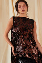 a model wearing a Sparkly Brown Tie Back Top by Sarvin and black sequin skirt.