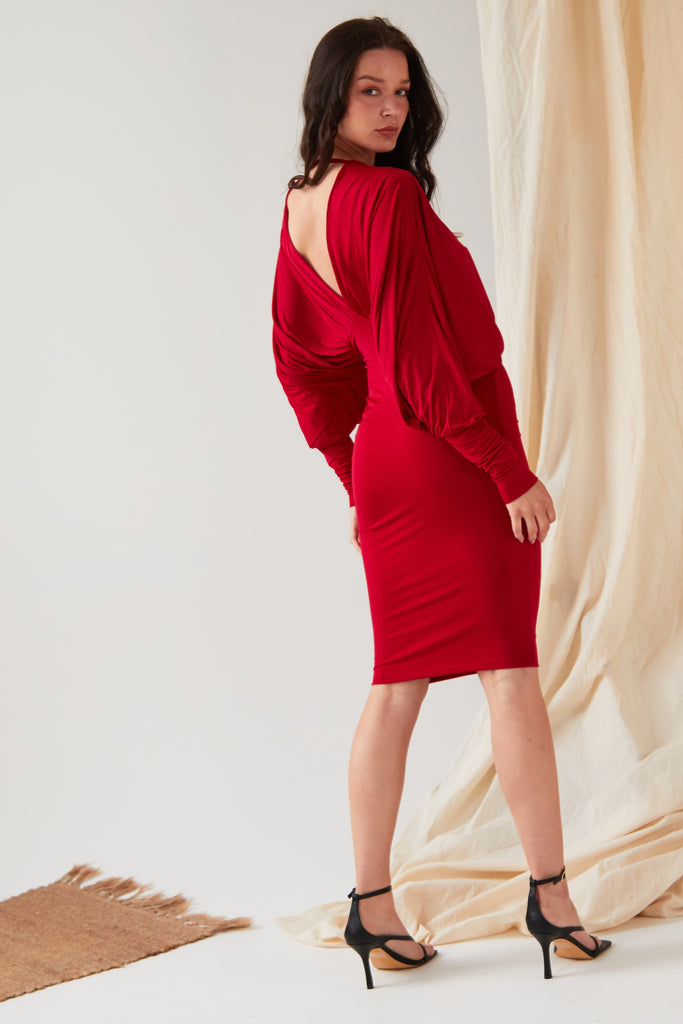 The back view of a woman in a Sarvin Red Batwing Dress.