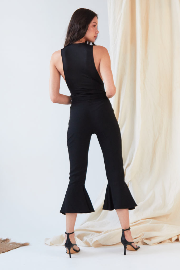 the back view of a woman wearing Sarvin's Black Frill Hem Trousers.