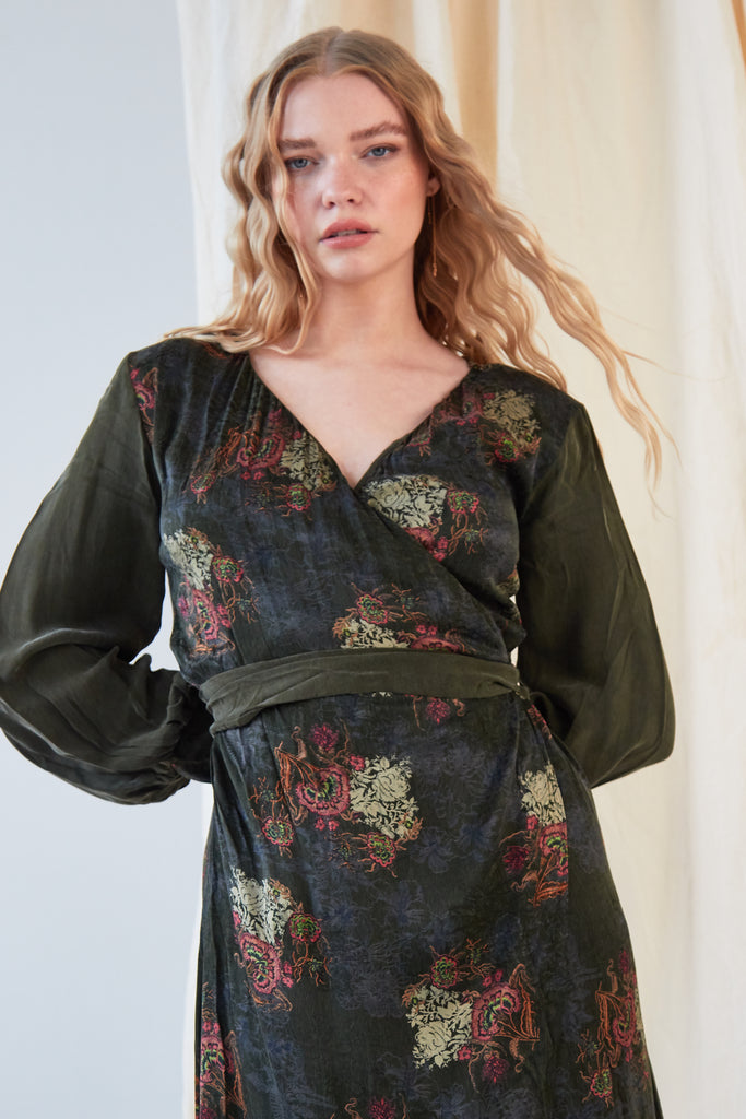 The model is wearing a Sarvin Long Sleeve Wrap Dress with a floral print.