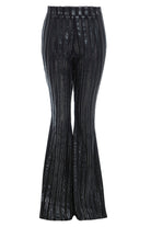 A woman's Sarvin black flared pants with a metallic striped pattern.