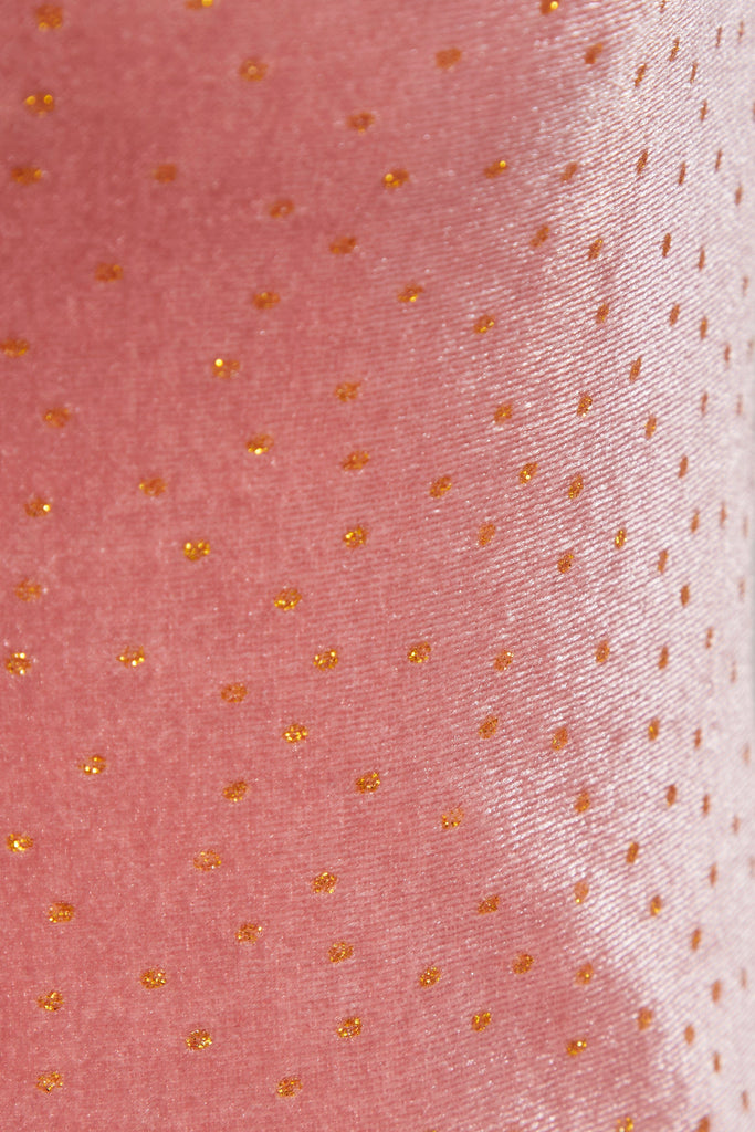 A close up of a Sarvin pink polka dot dress.