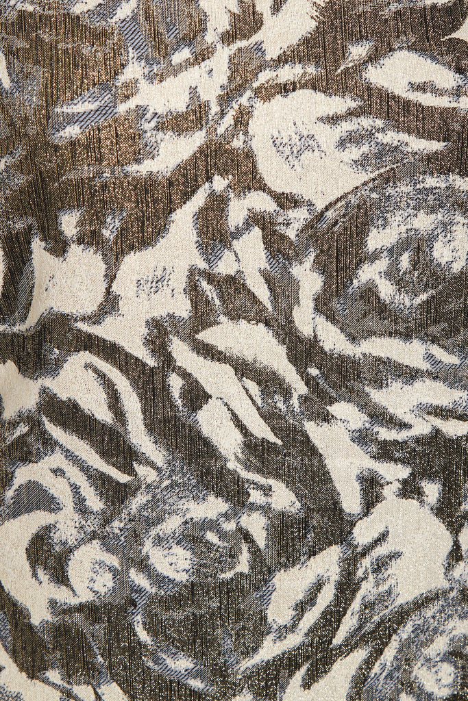 a close up of a Sarvin Puff Shoulder Dress in a brown and white pattern on a fabric.